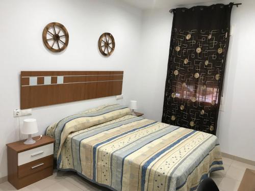1 dormitorio con 1 cama y reloj en la pared en Medina Azahara en El Higuerón