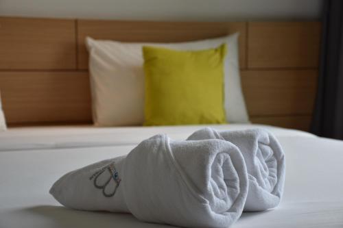 a pair of towels on a bed in a hotel room at B Boutique Residence in Suratthani