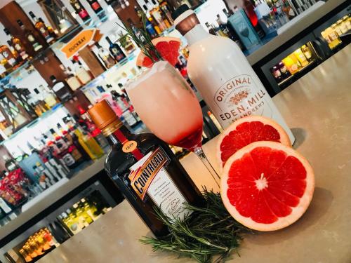 a bottle of alcohol and grapefruit slices on a counter at Duck Bay Hotel & Restaurant in Balloch