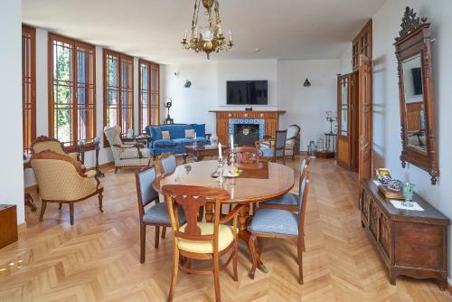 sala de estar con mesa, sillas y chimenea en Villa Taraça Alaçatı Romantik Otel, en Alacati