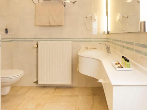 bagno bianco con lavandino e servizi igienici di Manoir thoveke a Lauwe