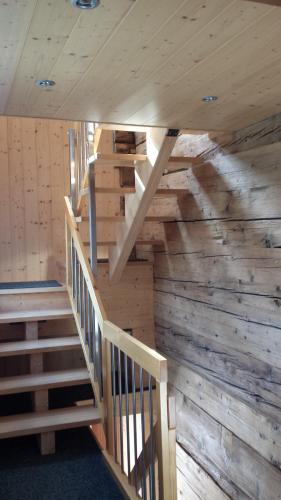 eine Treppe in einer Hütte mit Holzwänden und -decken in der Unterkunft Angela in Münster VS