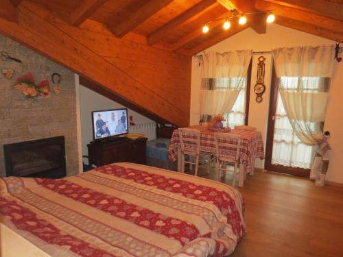 1 dormitorio con 2 camas, mesa y TV en Borgo Alpino Chalet 4, en Aprica