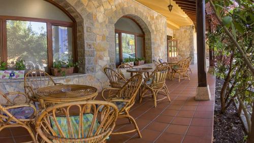 um pátio com mesas e cadeiras num edifício em Hotel El Angliru em Soto de Cangas