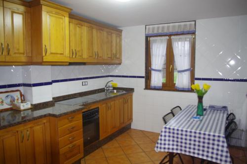 カンガス・デ・オニスにあるLa Vega del Sellaのキッチン(木製キャビネット、黄色い花のテーブル付)