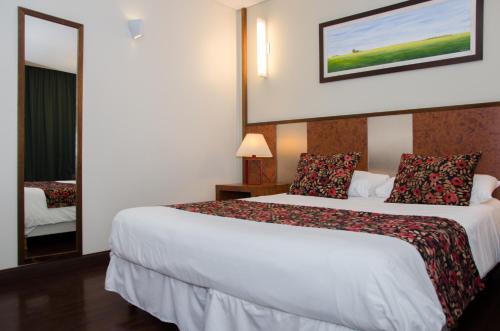 a hotel room with a bed and a mirror at 1412 Hotel Boutique in Rosario