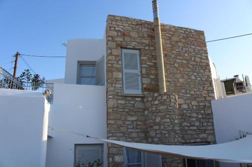 a building with a stone wall with a window at Guesthouse Casa De La Roca , Kostos , Paros in Kóstos