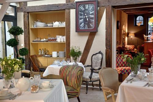 um restaurante com mesas e um relógio na parede em Hôtel St Pierre em Saumur