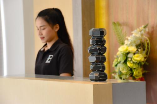 a woman sitting at a table with a black sculpture at B Boutique Residence in Suratthani
