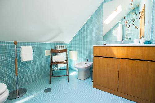 Baño azul con lavabo y aseo en Casa do Rossio by Home Sweet Home Aveiro en Aveiro