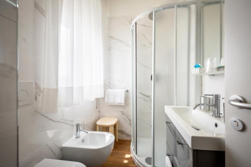 y baño blanco con lavabo y ducha. en Hotel Danieli, en Caorle