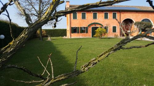 a large brick house with a green yard at Il Farfasole in Vigonovo
