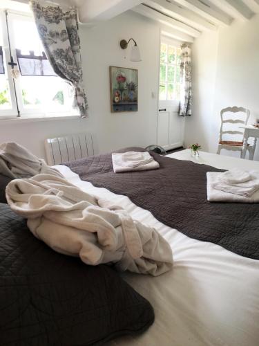 two large beds in a room with windows at La Romance et la Romanesque in Berville-sur-Mer