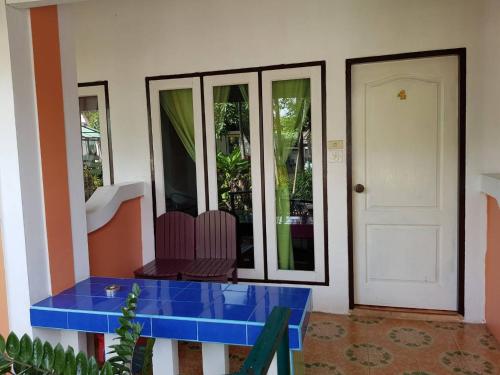a room with a blue table and a white door at Sam's House Kanchanaburi in Kanchanaburi City