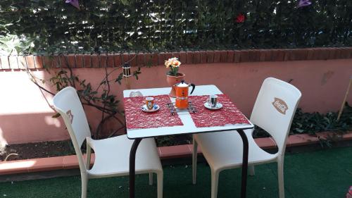 a table with two chairs and a tea pot on it at Holiday House Marlin in Giardini Naxos