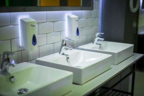 a bathroom with two sinks and two soap dispensers at Kick Ass Greyfriars (18+) in Edinburgh