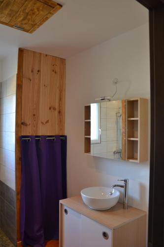 une salle de bain avec un lavabo et un miroir dans l'établissement Le Chêne, à Lagorce