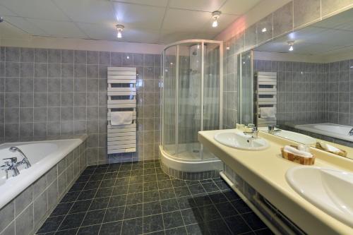 a bathroom with two sinks and a tub and a shower at Soleil et Jardin in Solaize