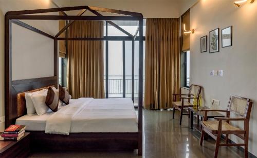 a bedroom with a large bed and a balcony at SaffronStays Falcon Hill, Lonavala - luxury villa with infinity pool near Lion's Point in Lonavala