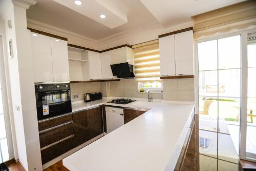 a kitchen with white cabinets and a white counter top at Penelope Villa in Belek