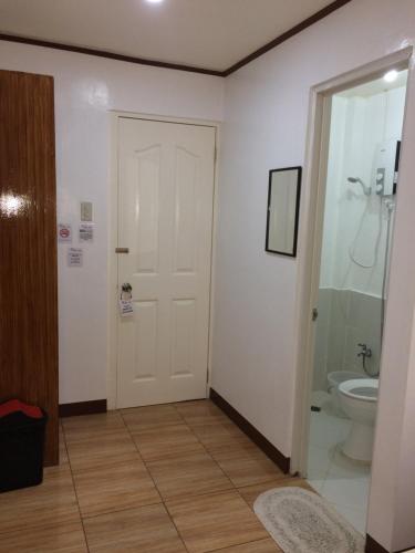 a bathroom with a white door and a toilet at Bella Vita Guest House in Coron