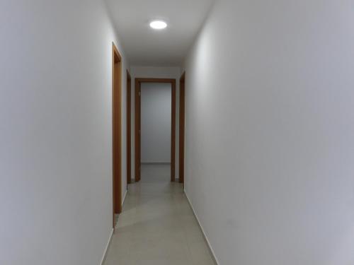 an empty corridor with white walls and a door at Arraial do Cabo in Arraial do Cabo