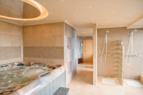 y baño grande con bañera y ducha. en Park Hotel Latgola en Daugavpils