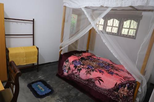 a bedroom with a canopy bed and a window at Prasad Suomi Villa in Matara