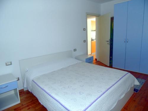 1 dormitorio con 1 cama blanca grande y armarios azules en Mini Viale Farra, en Feltre