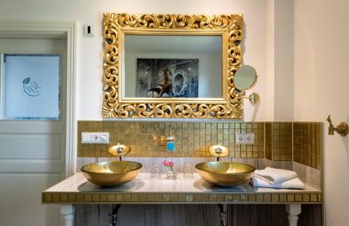 Baño con espejo y 2 lavabos de oro en Hotel Linther Hof, en Linthe
