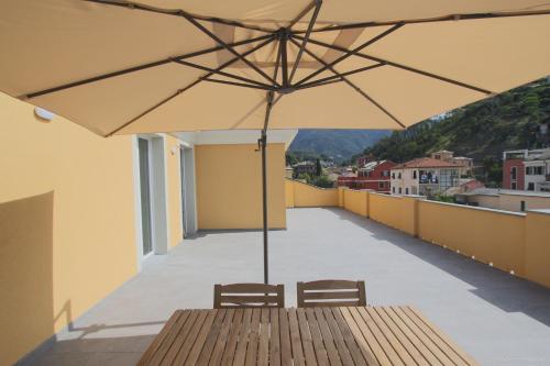a wooden table with an umbrella on a balcony at Santa Caterina in Levanto
