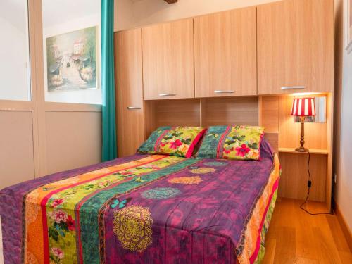 une chambre avec un grand lit avec une couverture colorée dans l'établissement La Maynadie, à Andouque