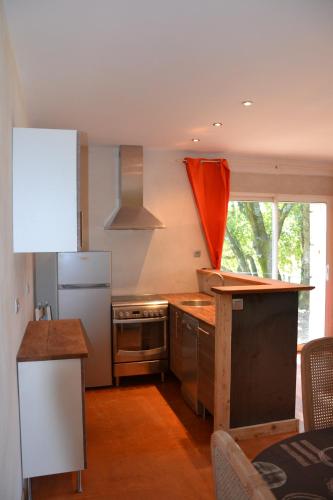 Il comprend une cuisine équipée d'un réfrigérateur blanc et d'une cuisinière. dans l'établissement Le Chêne, à Lagorce