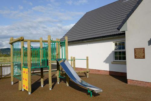 um parque infantil de madeira com um escorrega e um escorrega em Highland Gate, Stirling by Marston's Inns em Stirling