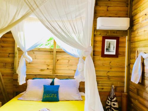 Tempat tidur dalam kamar di Bungalow de charme vue mer