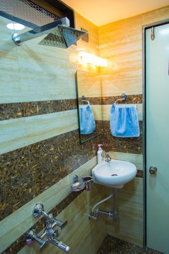a bathroom with a sink and a mirror at Hotel Tourister in Mumbai