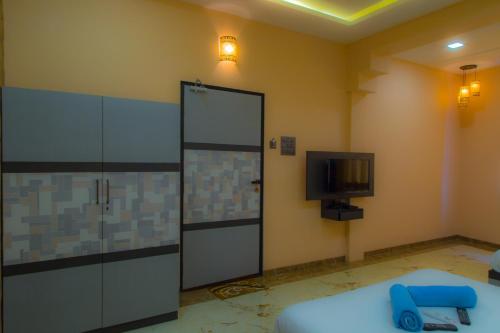 Zimmer mit Tür und TV in der Unterkunft Hotel Tourister in Mumbai