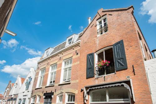 a red brick building with flowers in a window at De zeeuwse Suites in Middelburg