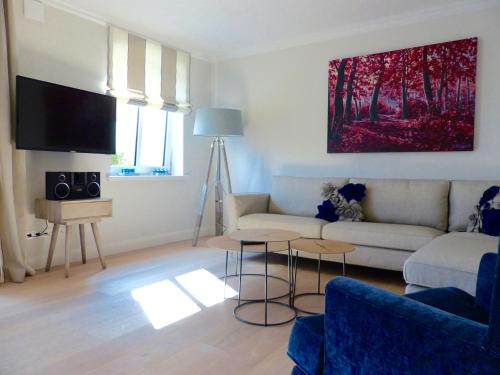 uma sala de estar com um sofá e uma televisão em Gartensuite No.5@Haus Mateika em Westerland