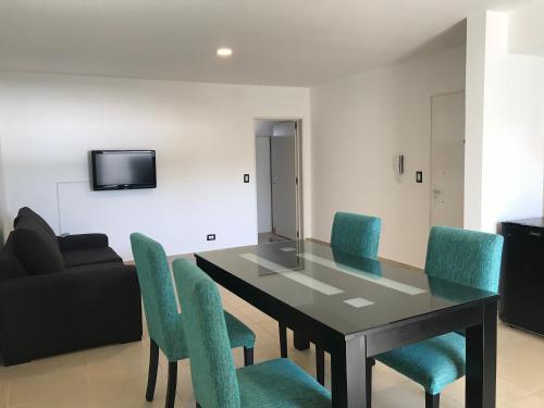 a dining room with a table and blue chairs at Mendoza Apartments Ezeiza Airport in Luis Guillón