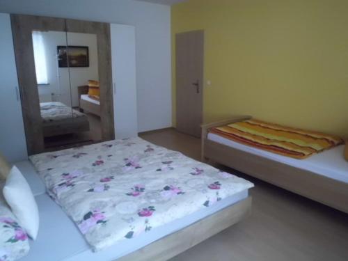 1 dormitorio con 2 camas y espejo en Ferienhaus Ulbricht beim Senftenberger See, en Hosena