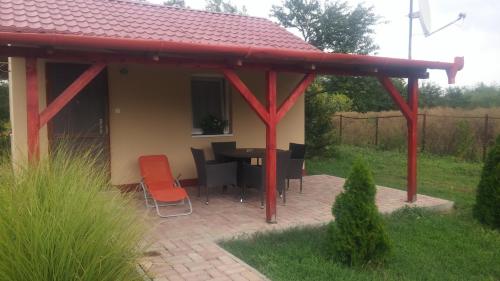 a pavilion with a table and chairs in a yard at Rákóczi Vendégház in Poroszló