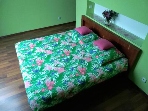 a bedroom with a bed with a green and pink blanket at 3-Pokojowy Apartament Villa Park - Top Location in Olsztyn