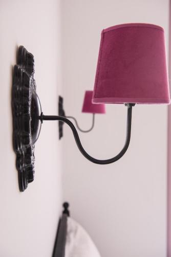 a phone hanging on a wall next to a lamp at Les suites du 17 in Aigues-Mortes