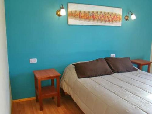 a bedroom with a bed and a blue wall at Rinconcito en Tilcara in Tilcara