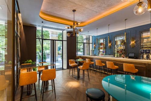 a restaurant with a bar with orange chairs and tables at Room Mate Gorka in San Sebastián