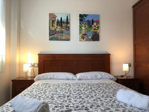 a bedroom with a bed with three pictures on the wall at Casa Rural La Guea de Teruel in Teruel