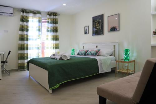 a bedroom with a bed with a green blanket at centruMassimo b&b in Palermo