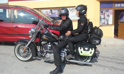 two people are sitting on a motorcycle at Hotel Bebej Tradicional in Gjirokastër