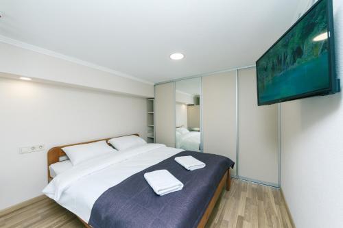 a bedroom with a bed and a tv on a wall at BeRest Plus in Kyiv